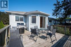 Expansive wooden deck with railing, featuring vinyl siding exterior and sliding glass doors - 
