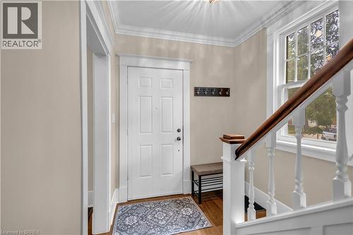 Panel door entry with crown molding, wood-finish flooring, and a traditional staircase featuring a wood handrail - 11 Tutela Heights Road, Brantford, ON 