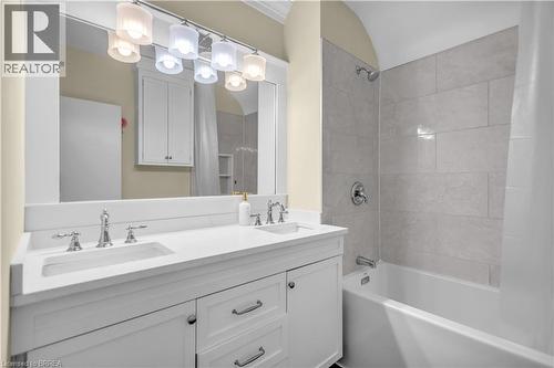 Dual sink vanity with white cabinetry, polished chrome fixtures, and a large mirror - 11 Tutela Heights Road, Brantford, ON 