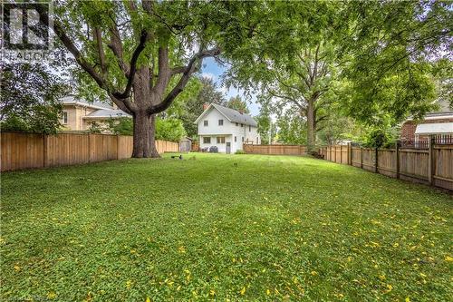 Expansive backyard with a large lawn, mature trees, and wood privacy fencing - 11 Tutela Heights Road, Brantford, ON 
