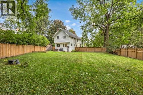 Expansive backyard featuring a manicured lawn, full wood fencing, and mature trees - 11 Tutela Heights Road, Brantford, ON 
