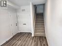 Wood-finish flooring, white paneled doors, matte black hardware, and carpeted stairs with a light wood handrail - 155 Equestrian Way Unit# 152, Cambridge, ON 