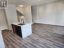 Kitchen island with stone countertop, undermount sink, and matte black faucet - 155 Equestrian Way Unit# 152, Cambridge, ON 