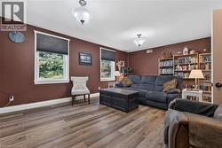 Spacious room featuring wood-finish flooring and two distinct built-in bookshelves - 