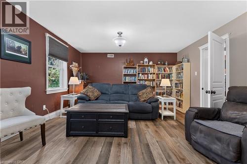 Spacious room featuring wood-finish flooring, a ceiling-mounted light fixture, and a window with white trim - 42841 Highway 3, Wainfleet, ON 
