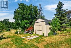 Spacious backyard featuring a utility shed with a gambrel roof and double doors - 