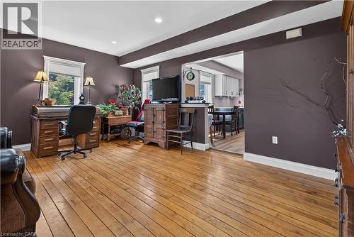 Hardwood flooring and recessed lighting define this interior space, featuring a wide doorway opening to a dining area with white cabinetry - 42841 Highway 3, Wainfleet, ON 