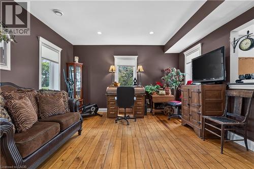 Spacious room with wood-finish flooring, multiple windows with white trim, recessed ceiling lighting, and dark-toned walls - 42841 Highway 3, Wainfleet, ON 