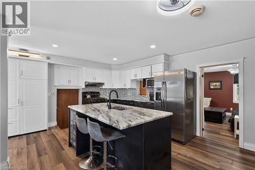 Modern kitchen featuring a central island with a granite-style countertop and integrated sink - 42841 Highway 3, Wainfleet, ON 
