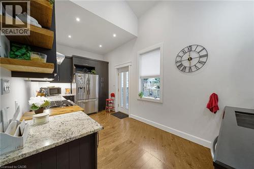 Kitchen featuring wood-finish flooring, recessed lighting, dark cabinetry, and light-toned countertops - 28 Cambridge Street, Cambridge, ON 