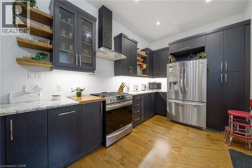 Hardwood flooring, stainless steel appliances, dark cabinetry, light countertops, and open shelving - 28 Cambridge Street, Cambridge, ON 