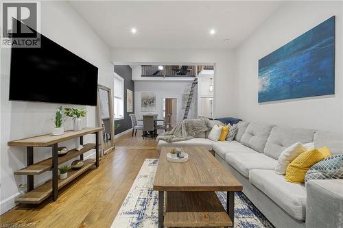 Open-concept living space with wood-finish flooring, recessed lighting, and a partial second-story overlook - 28 Cambridge Street, Cambridge, ON 