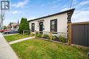 Stucco exterior with black trim windows, black front door, and decorative awning - 28 Cambridge Street, Cambridge, ON 
