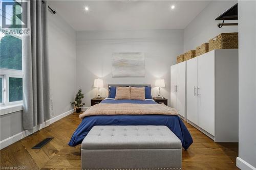Wood-finish flooring, white built-in cabinetry, recessed lighting, and a large window - 28 Cambridge Street, Cambridge, ON 