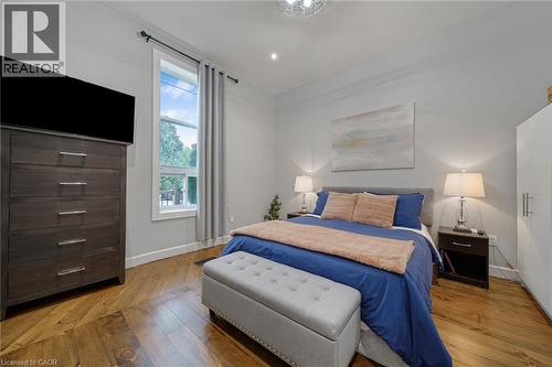 Hardwood flooring, tall window with white trim, built-in recessed lighting, and a neutral wall color - 28 Cambridge Street, Cambridge, ON 