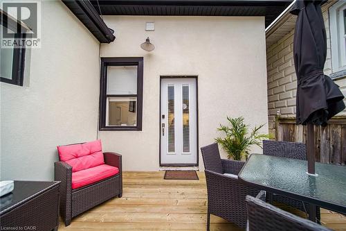 Outdoor wood-finish decking with an exterior light fixture and a white paneled door - 28 Cambridge Street, Cambridge, ON 