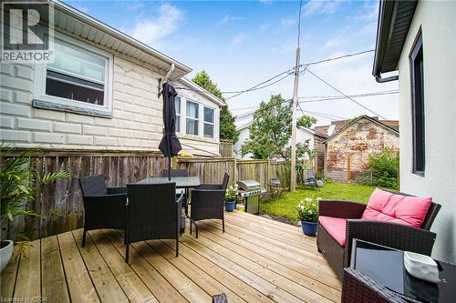 Wooden deck with a privacy fence, an adjacent grassy area, and a white stucco exterior - 28 Cambridge Street, Cambridge, ON 