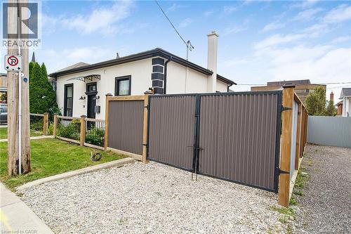 White stucco exterior with black trim accents and a black entry door - 28 Cambridge Street, Cambridge, ON 