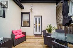 Outdoor wood-finish decking with an exterior light fixture and a white paneled door - 