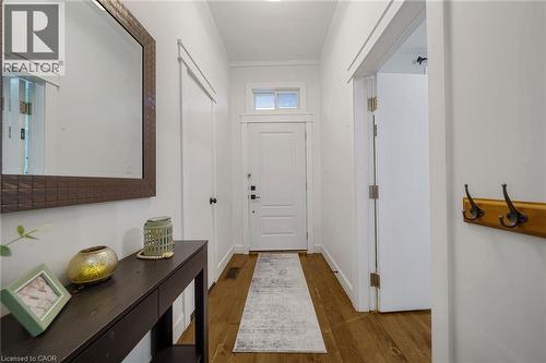 White entry door with transom window, wood-finish flooring, and a built-in coat rack - 28 Cambridge Street, Cambridge, ON 