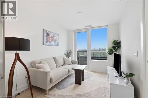 Expansive windows, light wood-finish flooring, white walls, recessed lighting, and a cityscape backdrop - 60 Central Park Roadway Unit# 2010, Etobicoke, ON 