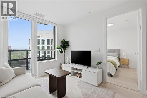 Expansive window wall with balcony access, light wood-finish flooring, recessed lighting, and a neutral color palette - 60 Central Park Roadway Unit# 2010, Etobicoke, ON 
