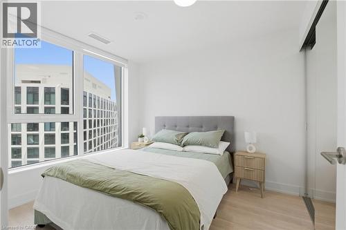 Expansive window with roller shade, light wood-finish flooring, recessed ceiling lighting, and a sliding barn door - 60 Central Park Roadway Unit# 2010, Etobicoke, ON 