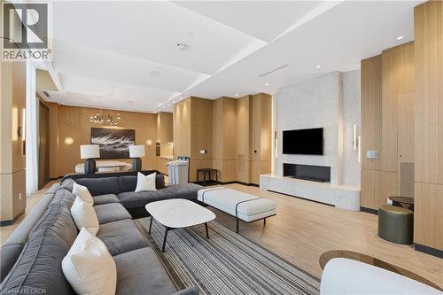 Expansive common area featuring wood-finish wall paneling, a built-in fireplace, and recessed ceiling lighting - 60 Central Park Roadway Unit# 2010, Etobicoke, ON 
