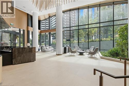 Expansive lobby with high ceilings, floor-to-ceiling windows, light-toned large format tile flooring, and a dark marble reception desk - 60 Central Park Roadway Unit# 2010, Etobicoke, ON 