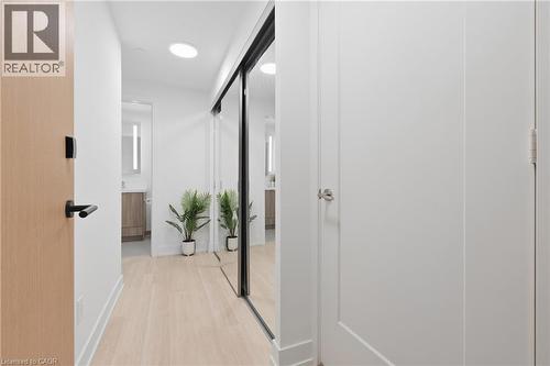 Light wood-finish flooring with recessed ceiling lighting, a full-height mirrored sliding closet door, and a light wood-finish entry door with black hardware - 60 Central Park Roadway Unit# 2010, Etobicoke, ON 