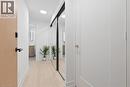 Light wood-finish flooring with recessed ceiling lighting, a full-height mirrored sliding closet door, and a light wood-finish entry door with black hardware - 60 Central Park Roadway Unit# 2010, Etobicoke, ON 
