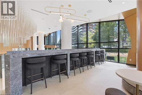 Expansive full-height windows, polished stone-finish bar, recessed lighting, and a decorative overhead light fixture - 60 Central Park Roadway Unit# 2010, Etobicoke, ON 