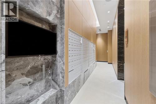 Marble-clad accent wall with built-in media niche, wood paneling, recessed lighting, and wall-mounted mailboxes - 60 Central Park Roadway Unit# 2010, Etobicoke, ON 