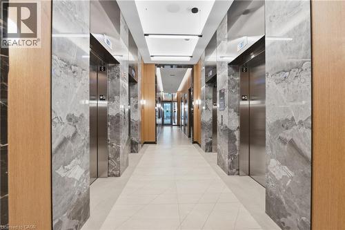 Multiple stainless steel elevators framed by wood-finish and stone-look paneling - 60 Central Park Roadway Unit# 2010, Etobicoke, ON 
