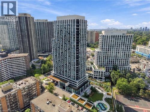 Modern high-rise residential building featuring a distinct facade, multiple balconies, a ground-level amenity area with green space, and a hardscaped terrace - 60 Central Park Roadway Unit# 2010, Etobicoke, ON 