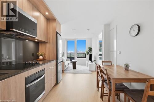 Integrated kitchen with wood-finish cabinetry, stainless steel appliances, and dark countertops - 60 Central Park Roadway Unit# 2010, Etobicoke, ON 