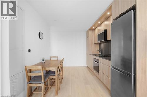 Kitchen with wood-finish cabinetry, integrated stainless steel appliances, and wood-finish flooring - 60 Central Park Roadway Unit# 2010, Etobicoke, ON 