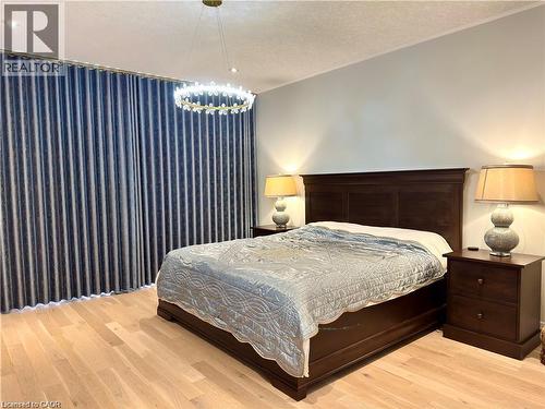Hardwood flooring, full-height privacy drapes, and a decorative ceiling light fixture - 923 Eaglecrest Court, Kitchener, ON 