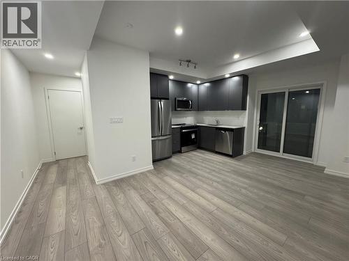 Modern kitchen with dark cabinetry, stainless steel appliances, and light-toned countertops - 17 Lytham Green Circle Unit# 27, Newmarket, ON 