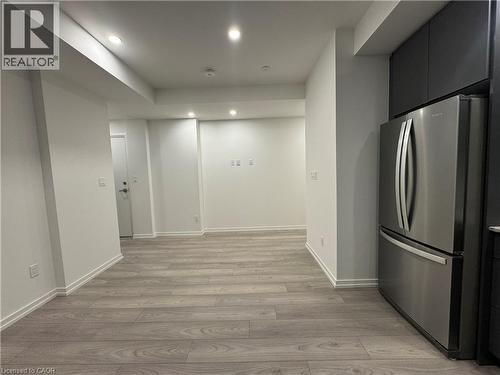 Integrated kitchen with stainless steel refrigerator and dark cabinetry - 17 Lytham Green Circle Unit# 27, Newmarket, ON 