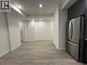 Integrated kitchen with stainless steel refrigerator and dark cabinetry - 17 Lytham Green Circle Unit# 27, Newmarket, ON 