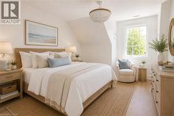 Bright sleeping quarters featuring wood-finish flooring, a contemporary chandelier, a window with exterior views, built-in shelving, and a wood-finish dresser with black hardware - 