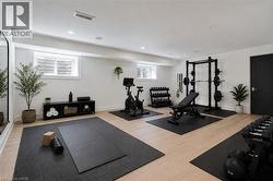Dedicated fitness area featuring light wood-finish flooring, recessed lighting, and white walls - 