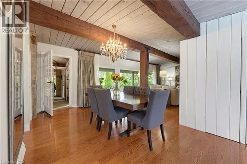 Hardwood flooring with exposed ceiling beams and a chandelier - 1316 Nevarc Drive, Burlington, ON 