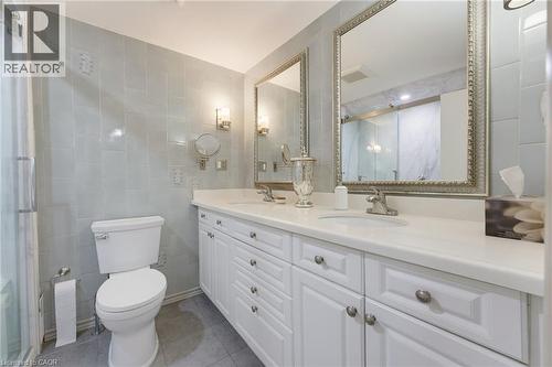 Dual vanity with white cabinetry, white countertops, and silver-framed mirrors - 1316 Nevarc Drive, Burlington, ON 