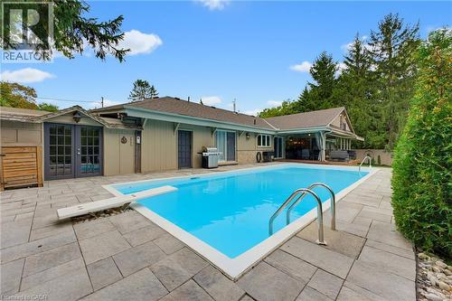 Swimming pool with an integrated diving board and stainless steel handrails - 1316 Nevarc Drive, Burlington, ON 