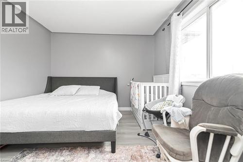 Neutral wall paint, window with vertical blinds, and wood-finish flooring - 42 Saturn Road, Port Colborne, ON 