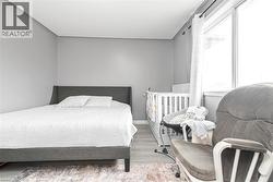 Neutral wall paint, window with vertical blinds, and wood-finish flooring - 