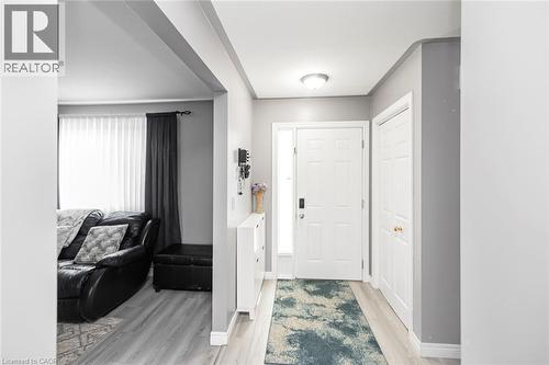 Recessed ceiling lighting, wood-finish flooring, white paneled doors, and a decorative frosted glass sidelight - 42 Saturn Road, Port Colborne, ON 