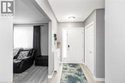 Recessed ceiling lighting, wood-finish flooring, white paneled doors, and a decorative frosted glass sidelight - 